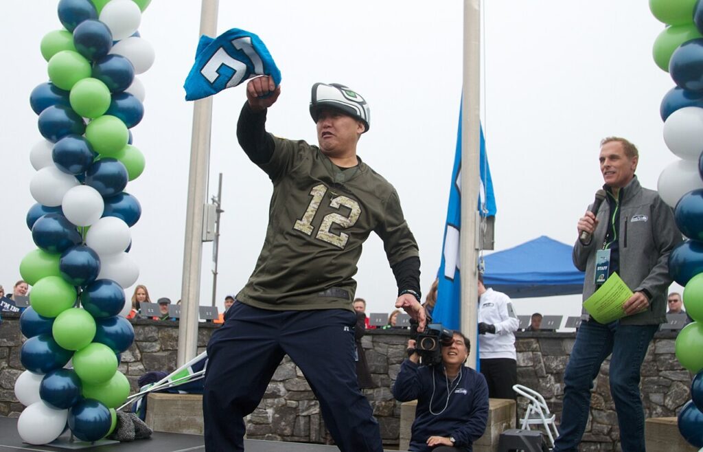 A Seattle Seahawks fan raising the 12th Man flag before a game