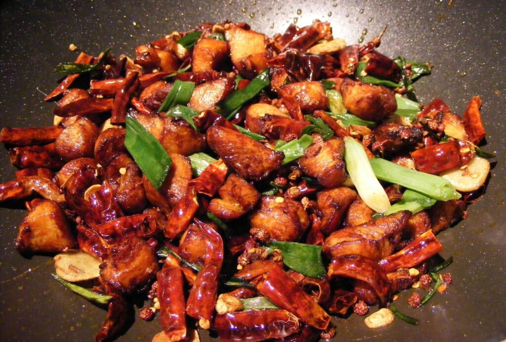 Flames leaping around a wok as vegetables are stir-fried at home