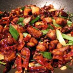 Flames leaping around a wok as vegetables are stir-fried at home